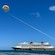 Three people parasailing near the Disney Wish cruise ship